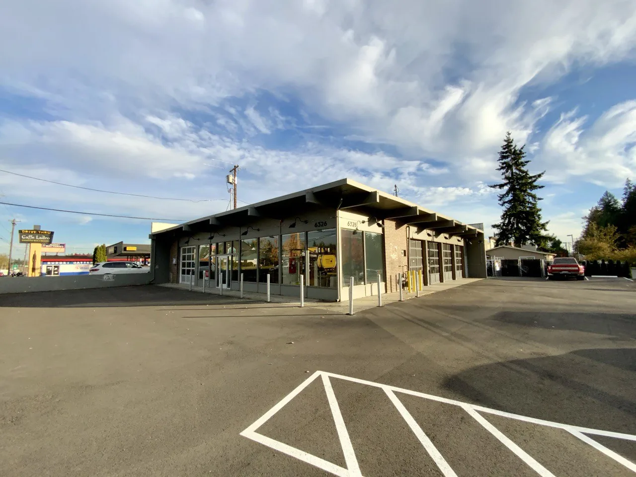 Lynnwood shop exterior with broad foreground parking area and dramatic sky.