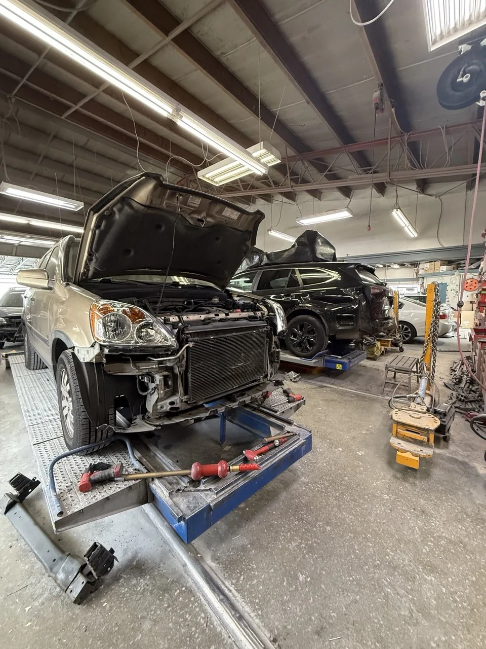 Vehicles raised on equipment in workshop.