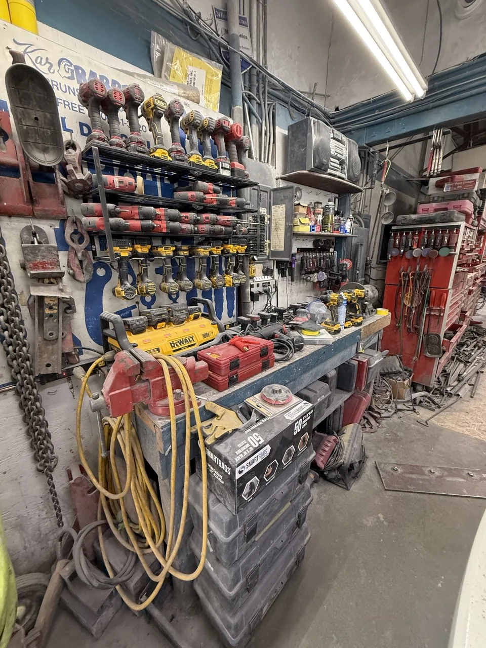 Workshop wall with collision repair tools and cables.