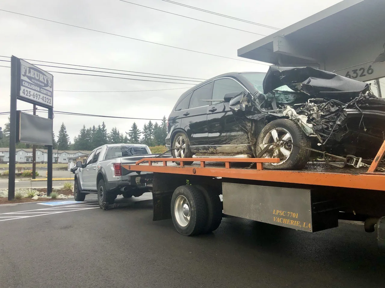 Damaged black vehicle on a flatbed outside Lynnwood.