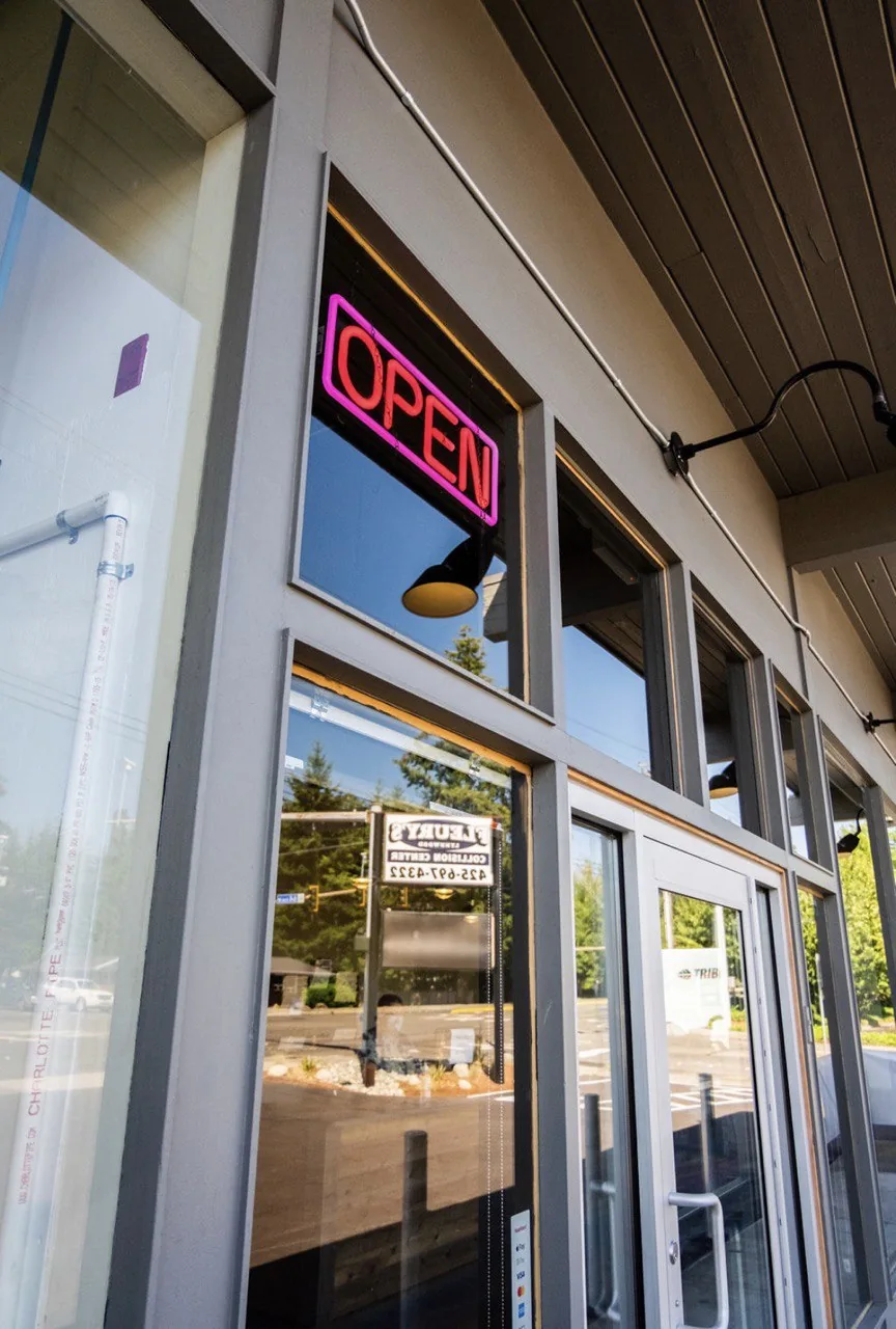 Open neon sign and glass entry door.