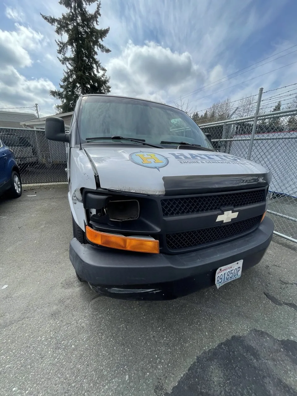 White commercial van with front-end damage.